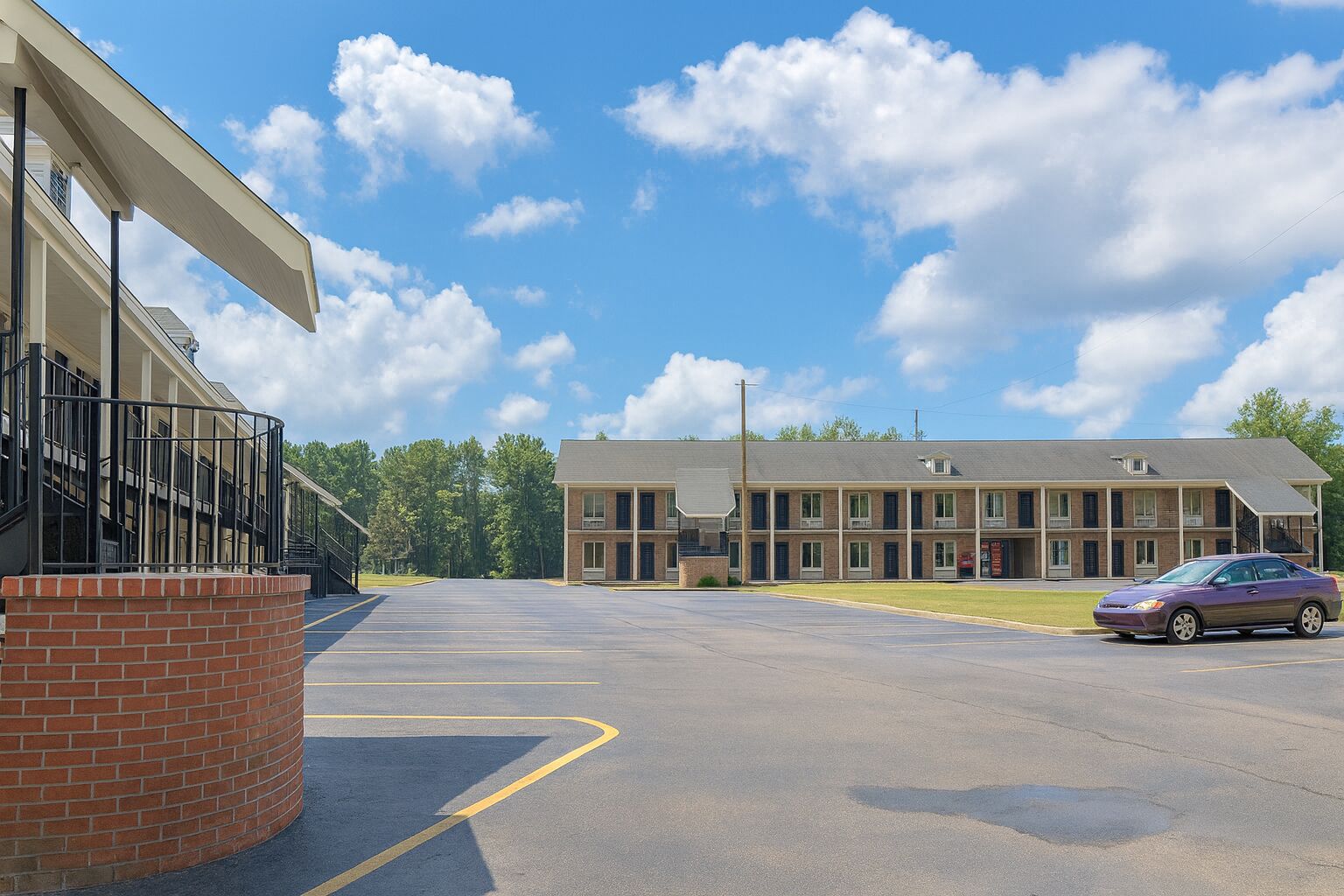 A parking lot with a building featuring a brick facade and a flat roof.