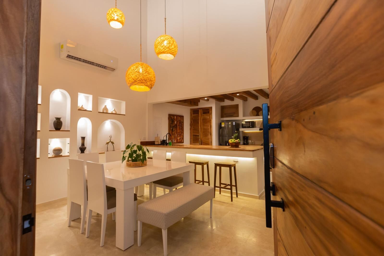 Een moderne keuken met witte kasten, een centraal eiland en hanglampen.