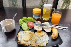A meal with eggs, toast, a banana, and a cup of coffee on a table.