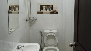 Une salle de bain équipée d’un lavabo, de toilettes et d’une douche.