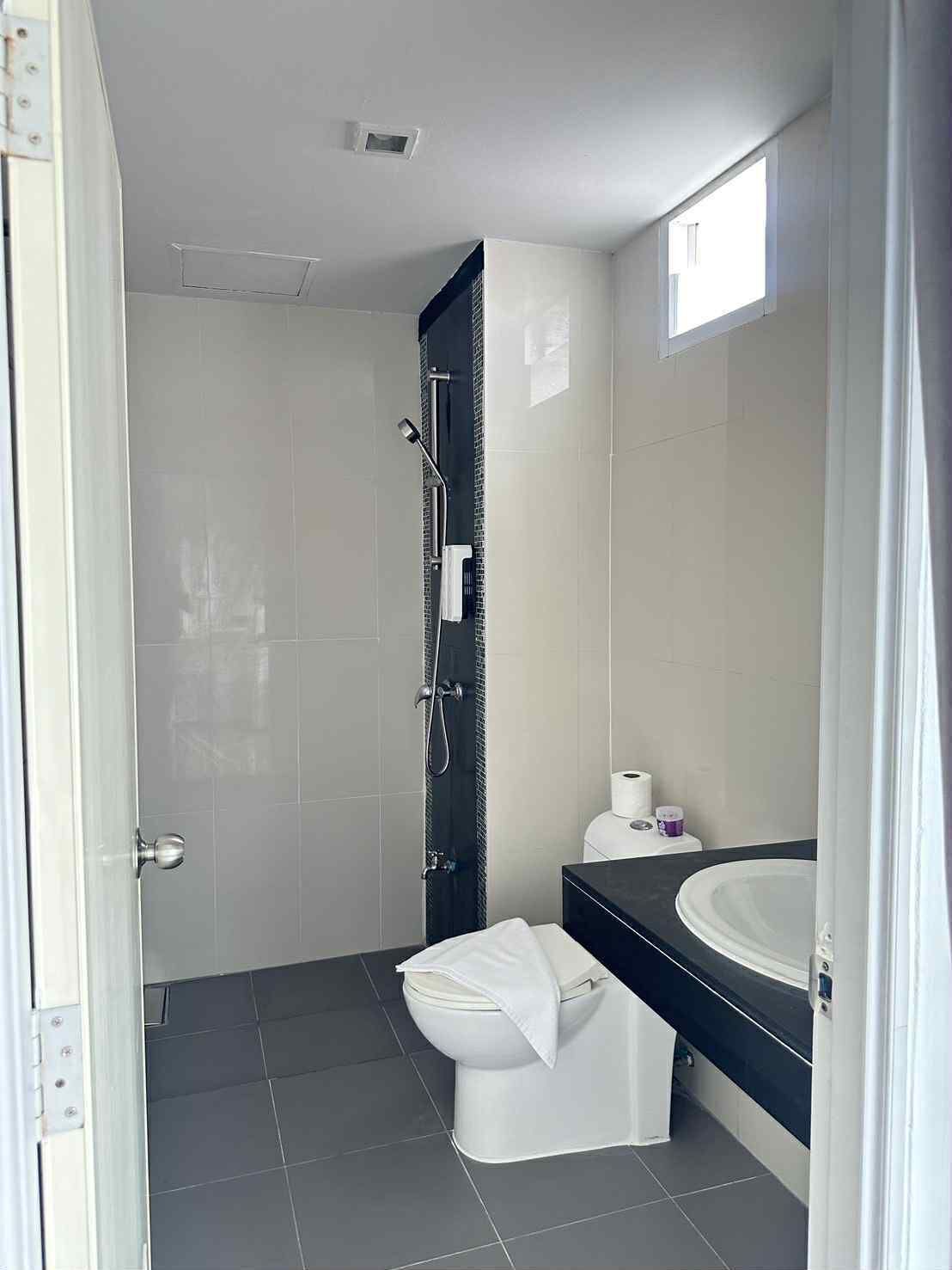 Ein modernes Badezimmer mit Toilette, Waschbecken und Dusche.