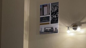 Ein Hotelzimmer mit einem ordentlich bezogenen Bett, einem Kopfteil und einer Wandleuchte.