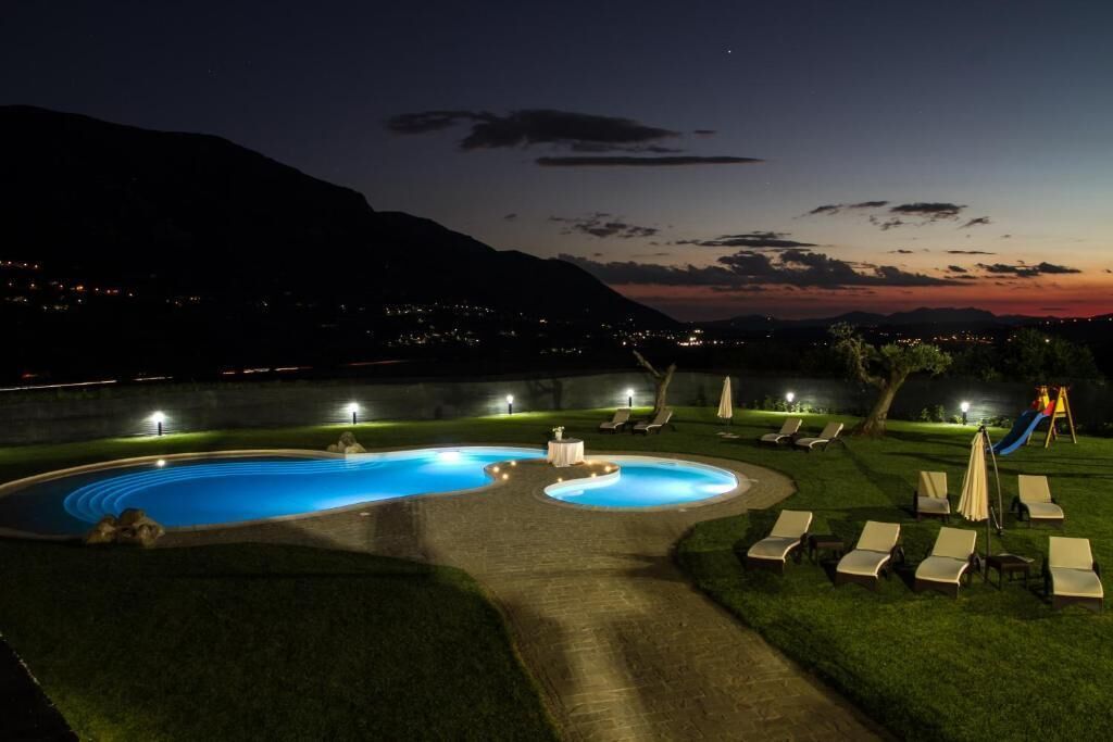 A swimming pool with a circular design, surrounded by lounge chairs and a play area.