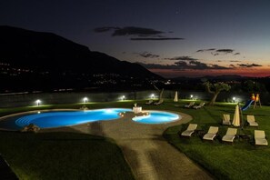 A swimming pool with a circular design, surrounded by lounge chairs and a play area. - Pietreionne (Ponte)