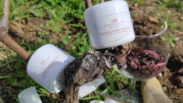 Zwei weiße Behälter mit der Aufschrift 'CREMA VISO Anti-clay' auf einem Ast.