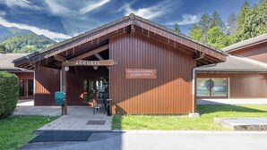 Puinen rakennus, jossa on kyltti, jossa lukee ”ACCUEL”, ja toinen kyltti, jossa lukee ”BIENVENUE AU DOMAINE DU GRAND TETRAS”.