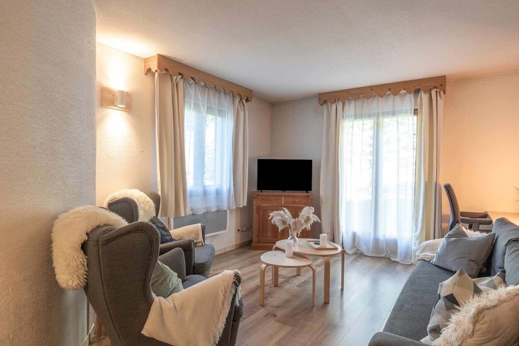 A cozy living room with a flat-screen TV, two sofas, a coffee table, and a TV stand.