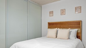 A bedroom with a large bed, a wooden headboard, and three framed pictures on the wall. - Terrace Allows Pets Free Parking Otium (Fajardo)