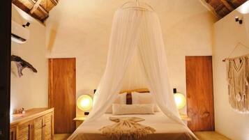 A room with a canopy bed, wooden walls, a wooden cabinet, and a wall-mounted lamp.