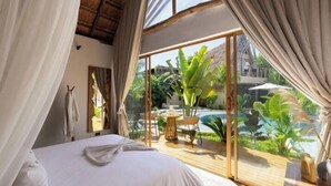 Un dormitorio con una cama grande, vistas a una piscina y un techo de paja.