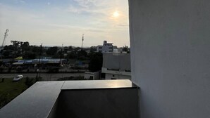 Un balcon offrant une vue sur le coucher de soleil au-dessus d’une ville.