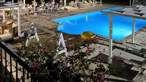 A pool area with a blue pool, white lounge chairs, and tables under pergolas. - Agriturismo Case Corboli Villetta Rovello (Todi)