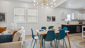 A modern kitchen with white cabinetry, a stainless steel dishwasher, and a central island. - Modern Indy Retreat with Hot Tub, Outdoor Oasis, Prime location to Lucas Oil (Indianapolis)