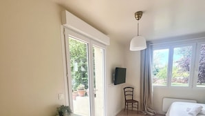 Une chambre à coucher avec un lit, un bureau, une chaise et un téléviseur.