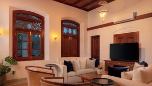 A living room with a sofa, two armchairs, a coffee table, a TV, and decorative lighting. - Oruva Beachside Villa (Galle)