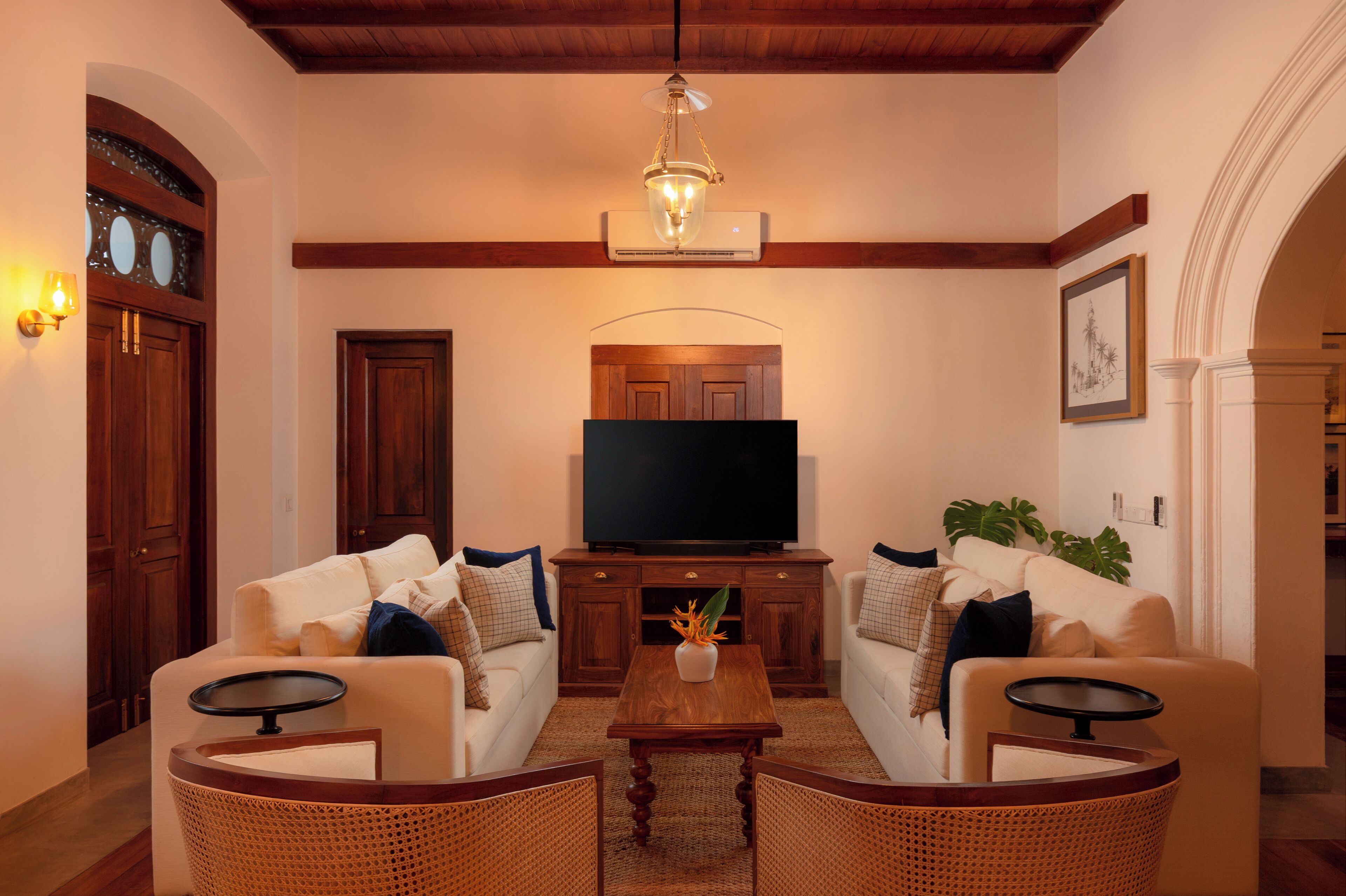 A living room with two sofas, a coffee table, a television, and a ceiling fan.