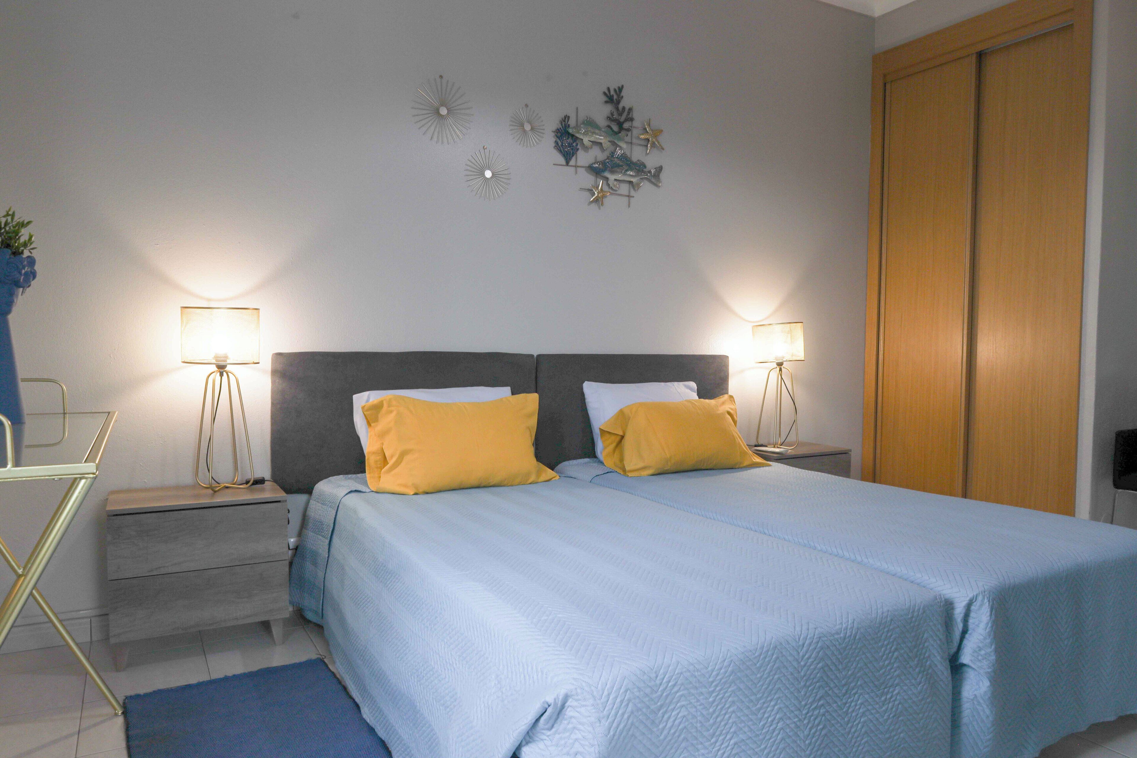 A bedroom with a bed, two bedside tables, and a nightstand.