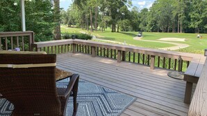 A covered deck with a view of a golf course. - Adorable Golf Course House in Tallahassee (Tallahassee)