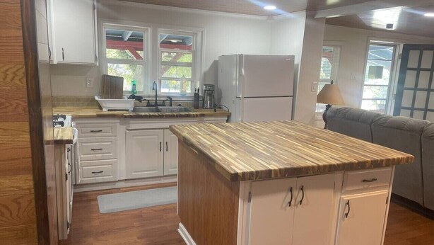 A kitchen with wooden cabinets, a countertop, and a refrigerator. - Four Bedroom house in Summerville GA (Summerville)
