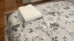 A bedroom with a bed, a television on a stand, a door leading to another room, and a window. - Four Bedroom house in Summerville GA (Summerville)