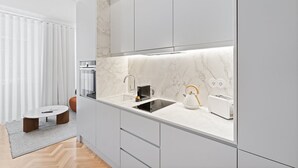 A modern kitchen with a marble countertop, a kettle, and a toaster.