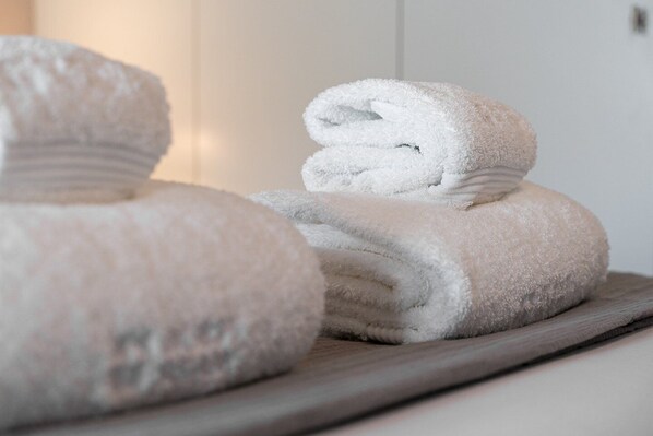 A stack of neatly folded towels on a wooden tray.