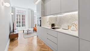 Eine moderne Küche mit Marmorfliesenspiegel, integriertem Spülbecken und einem Toaster.