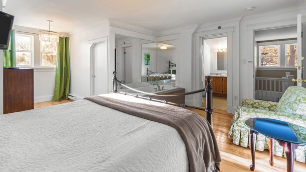 Quarto com cama, espelho, escrivaninha e cadeira.
