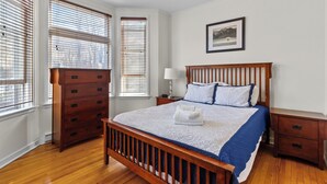A bedroom with a wooden bed, a dresser, and a nightstand. - Charming 2BR Wi-Fi Off-Street Parking (St. John's)