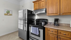 A kitchen with stainless steel appliances, wooden cabinets, and a coffee maker on the countertop. - Charming 2BR Wi-Fi Off-Street Parking (St. John's)