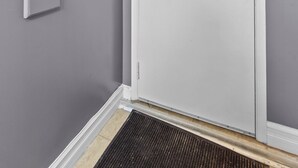 Une porte blanche avec le chiffre « 7 » au-dessus, un judas et un trou de serrure.