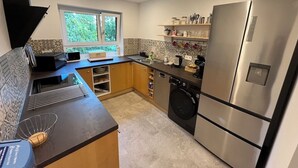A modern kitchen with a stainless steel refrigerator, a dishwasher, and a window providing natural light. - Modern vacation apartment in Marbach am Neckar in the immediate vicinity of the Schillerhöhe (Marbach am Neckar)