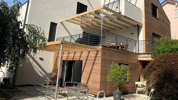 A modern two-story house with a balcony, a wooden deck, and a small garden area. - Modern vacation apartment in Marbach am Neckar in the immediate vicinity of the Schillerhöhe (Marbach am Neckar)