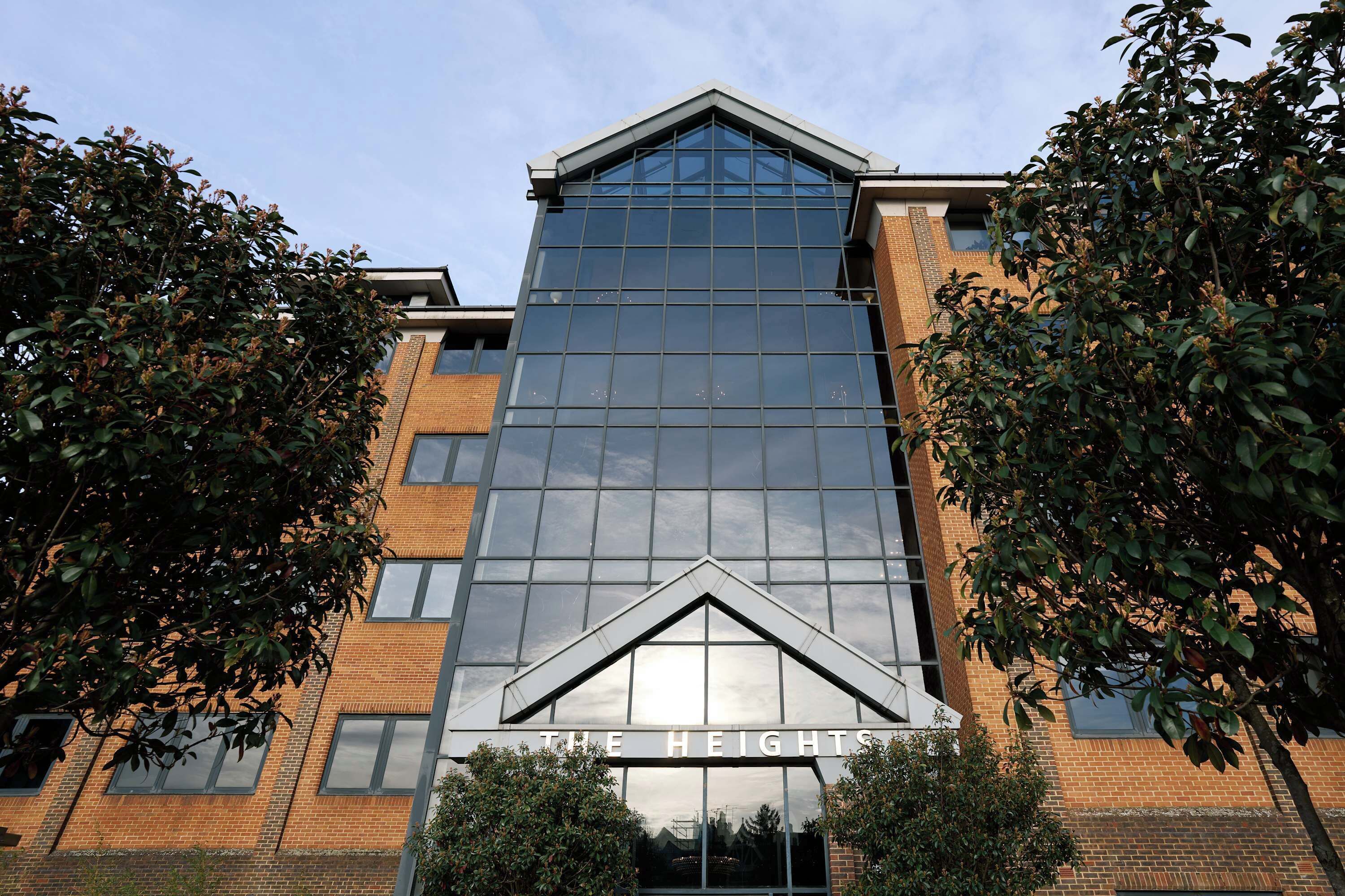 Un bâtiment moderne avec une façade en verre, sur lequel on peut lire en haut l’inscription « THE HEIGHTS ».