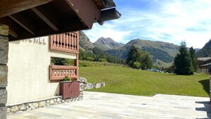 Une terrasse dallée de pierres offrant une vue sur les montagnes.