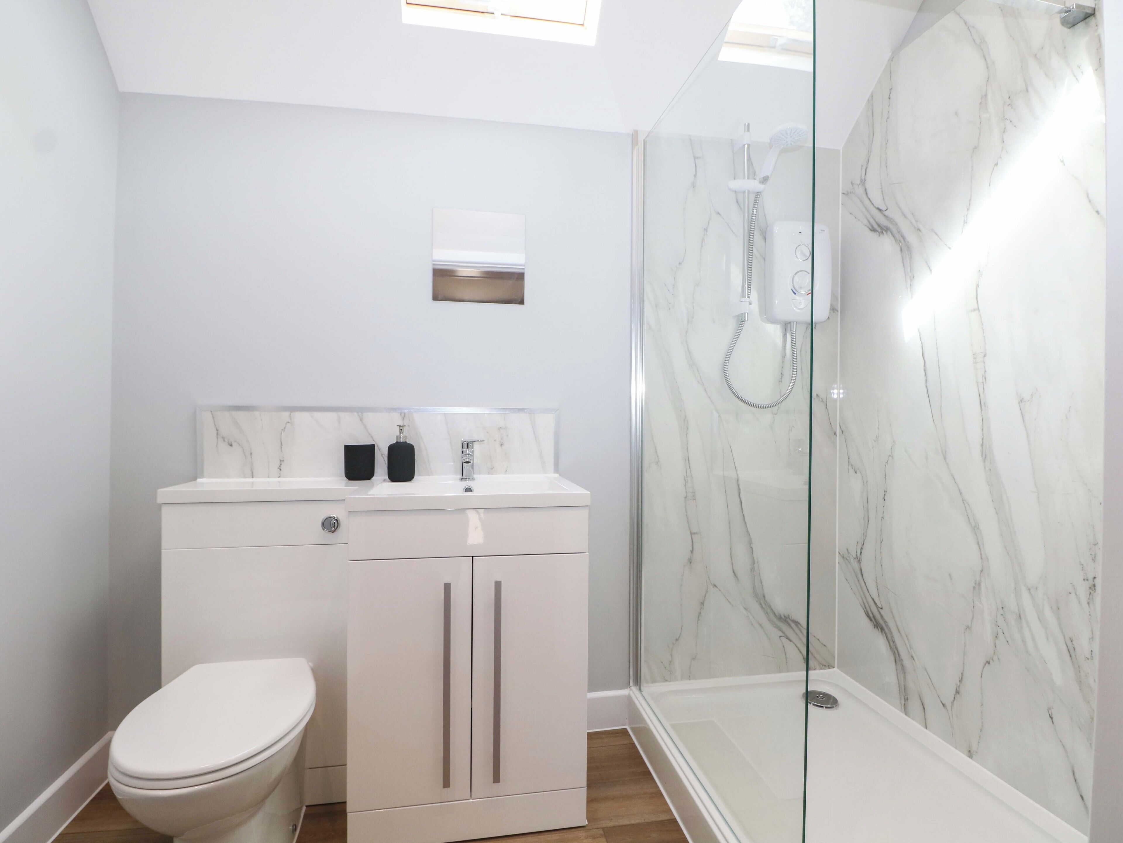 Un bagno moderno con il water, un lavabo e una cabina doccia in vetro.