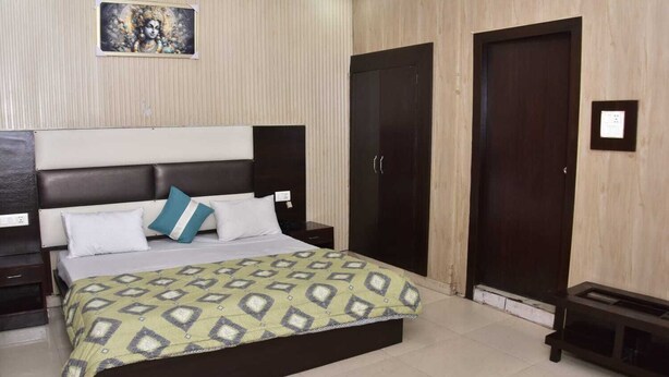 Una camera da letto con un letto, comodini, un armadio e un quadro appeso al muro.