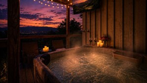 A hot tub with a sunset view, string lights, candles, and a painting. - Secluded Couples' Cabin - Fire pit, Hot Tub, Location, Views (Gatlinburg)