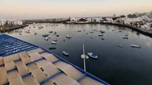 A marina with boats, a clear sky, and buildings in the background.