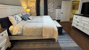 A neatly arranged bedroom with a bed, bedside tables, a dresser, a ceiling fan, and a television. - Cozy Modern Farmhouse (Port Matilda)