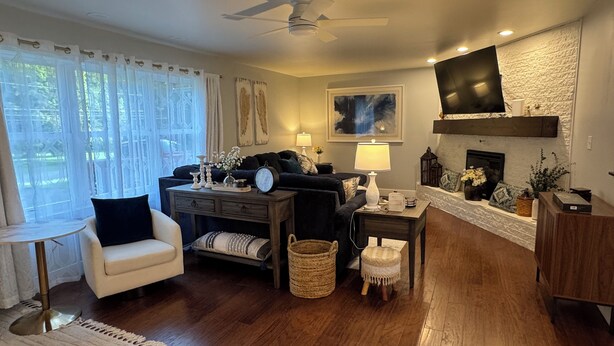 A living room with a sofa, armchair, coffee table, and a fireplace. - Cozy Modern Farmhouse (Port Matilda)