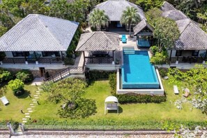 A resort with multiple buildings, a central swimming pool, and lush greenery.