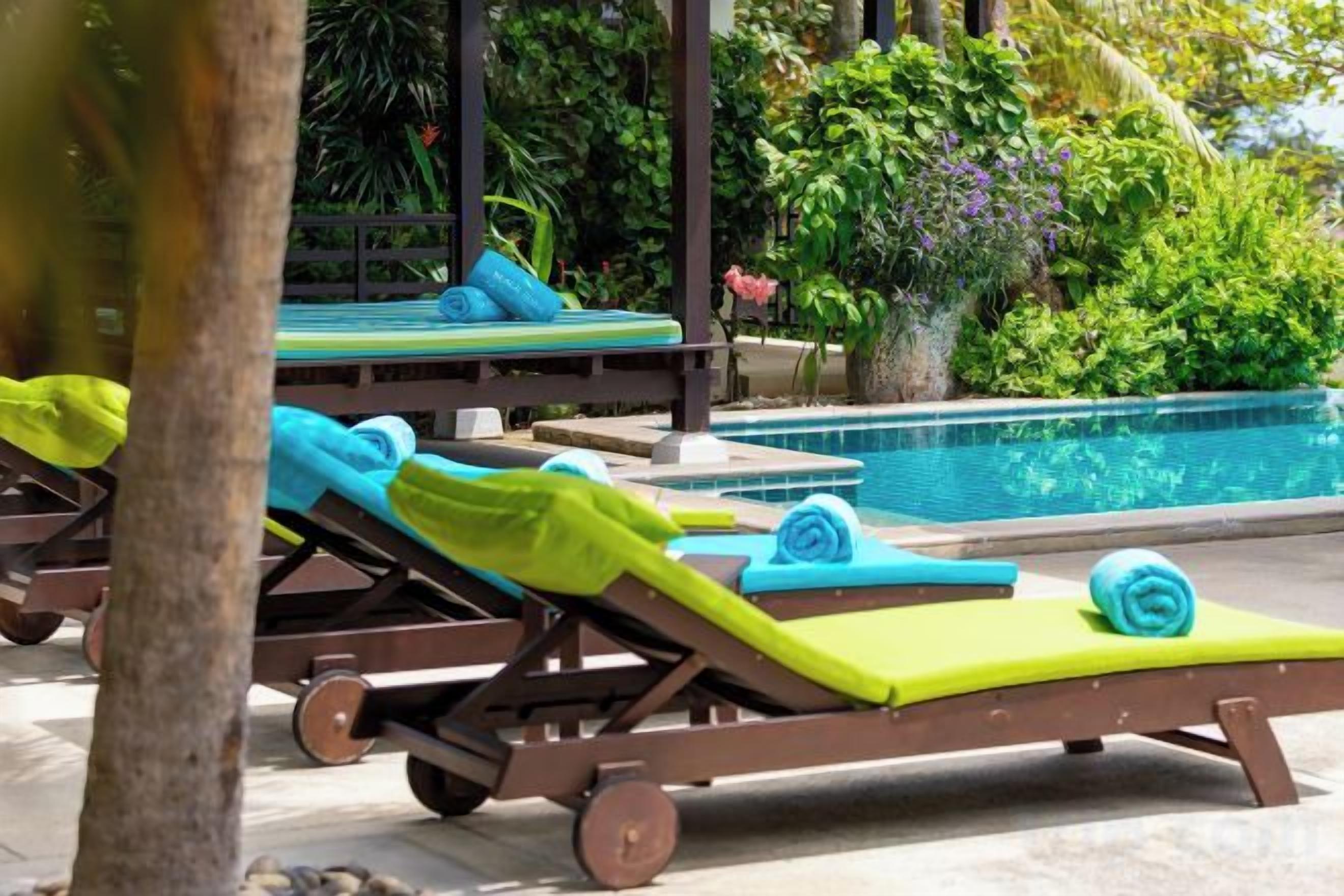 A poolside area with lounge chairs and a swimming pool.