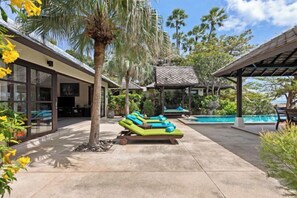 A poolside area with lounge chairs, a covered seating area, and a view of a pool. - Luxury Beachfront Pool Villa - Finu@Samui (Koh Samui)