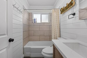 A compact bathroom with a bathtub, toilet, and a window. - Airdream Cottage/Gated Garage-HotTub Laundry W&D (Salt Lake City)