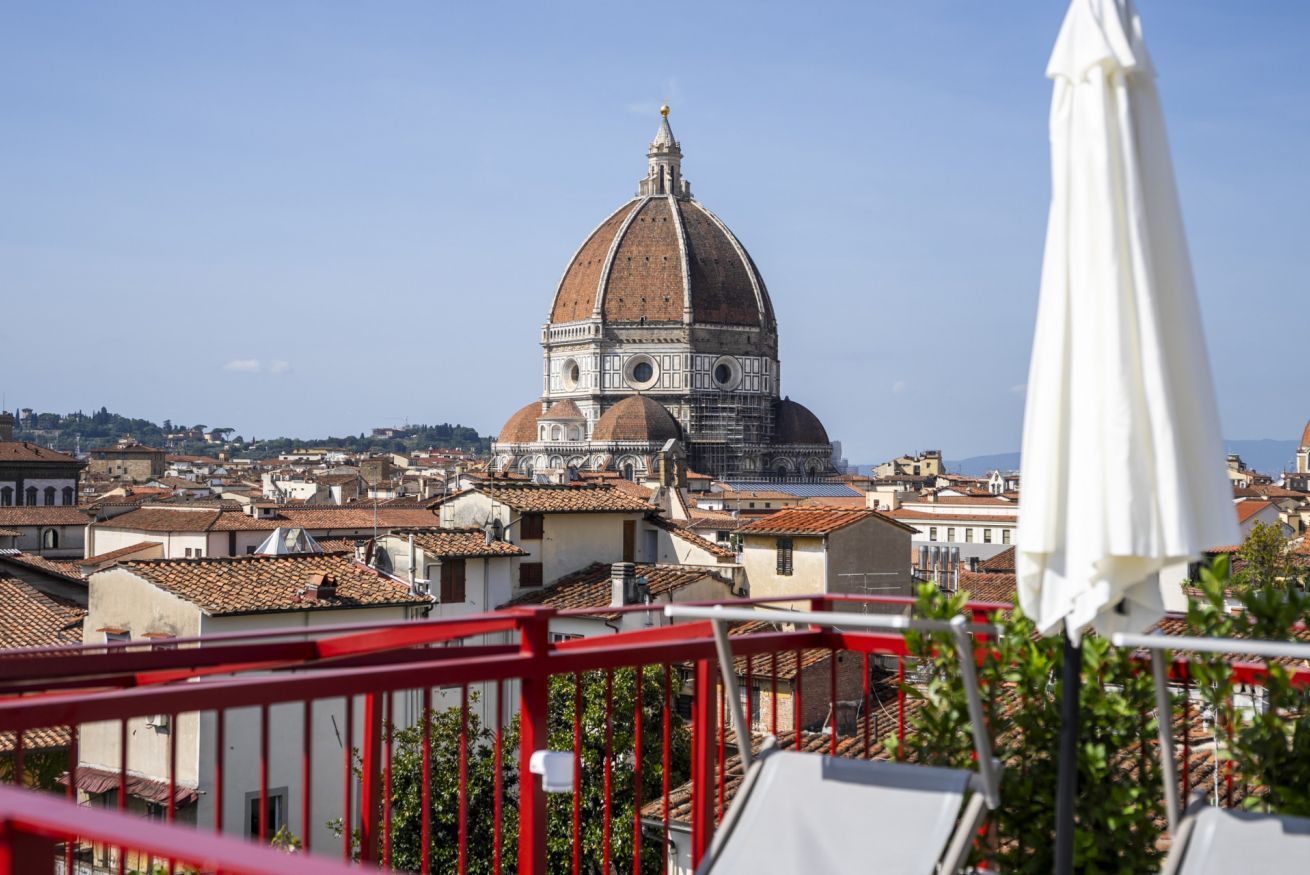 A view of a dome structure, likely a historical building, with surrounding urban architecture.