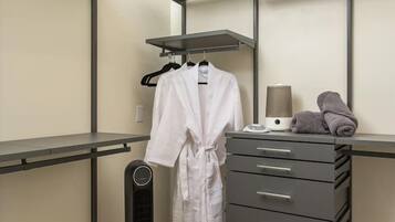 A walk-in closet with a mirrored wardrobe, a heater, and a towel rack.