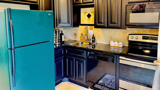 A kitchen with dark cabinetry, a teal refrigerator, a dishwasher, a sink, and a stove. - Getaway Spot Close to Red Rocks, Denver, Mtns (Lakewood)