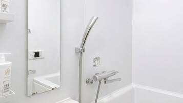 A modern bathroom with a shower, a mirror, and a white sink.