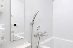 Een moderne badkamer met een douche, een spiegel en een witte wasbak.